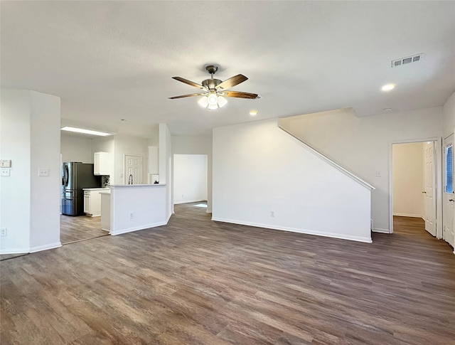 unfurnished living room featuring dark hardwood / wood-style floors and ceiling fan