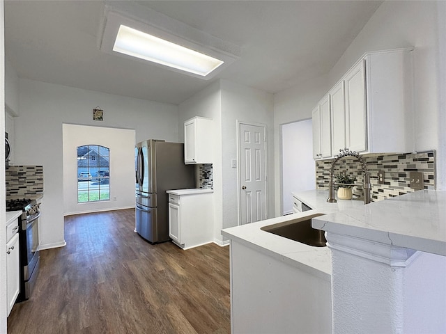 kitchen with dark wood-style floors, appliances with stainless steel finishes, white cabinets, and a sink