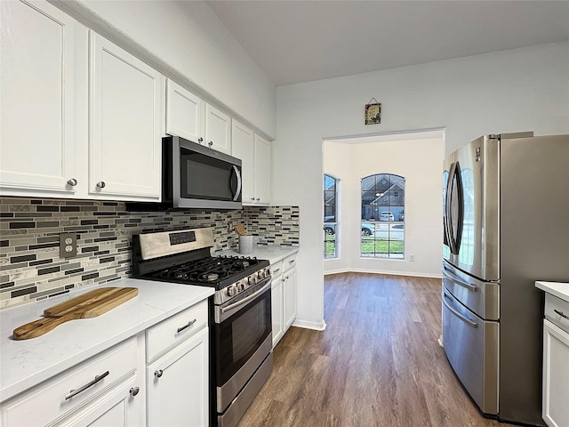 kitchen with stainless steel appliances, dark wood-style flooring, baseboards, white cabinets, and decorative backsplash