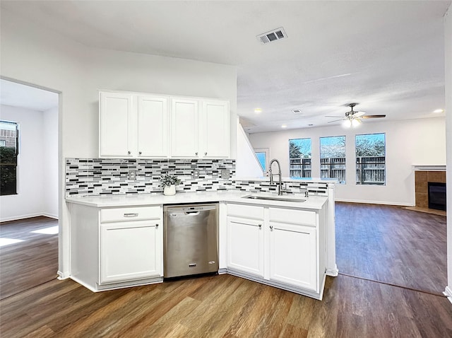 kitchen with a sink, white cabinetry, open floor plan, and dishwasher