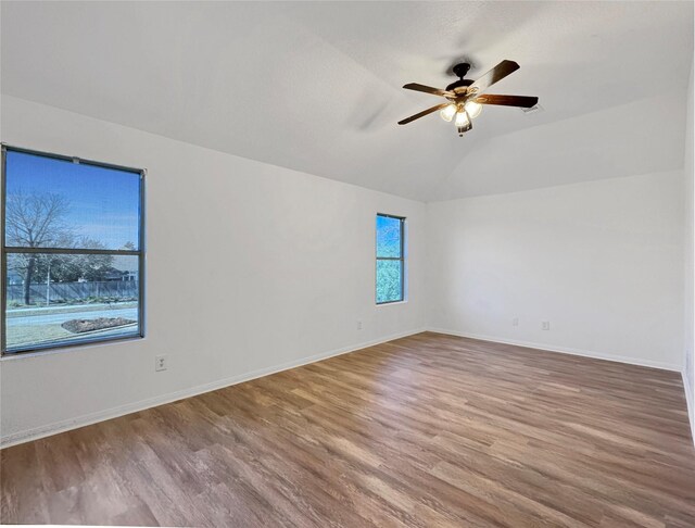 empty room featuring lofted ceiling, hardwood / wood-style flooring, and ceiling fan