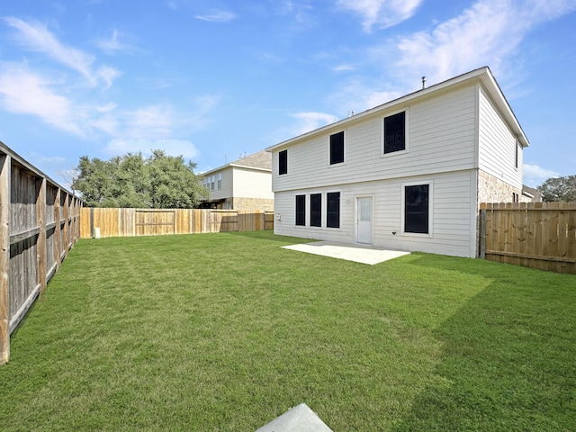 rear view of property with a yard, a patio area, and a fenced backyard