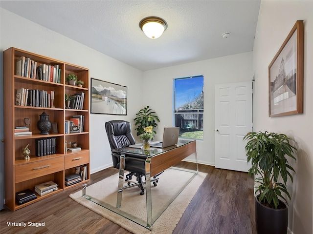 office space featuring a textured ceiling, dark wood-style flooring, and baseboards