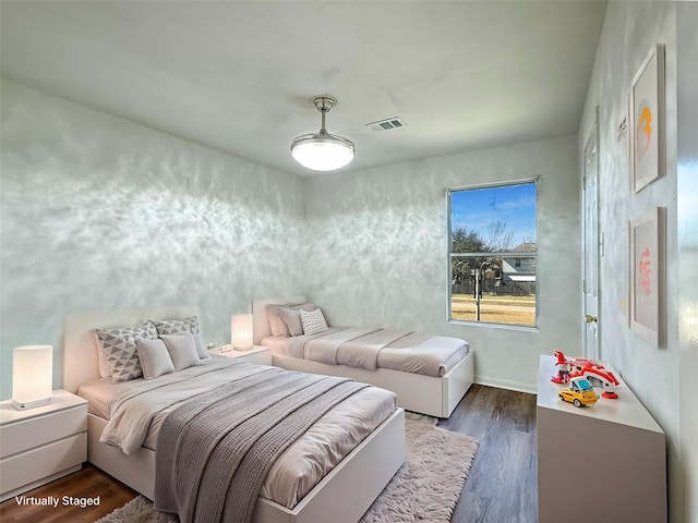 bedroom with dark wood-style flooring and visible vents