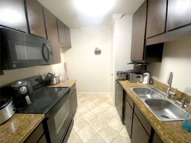 kitchen featuring sink, dark brown cabinets, light tile patterned floors, dark stone countertops, and black appliances