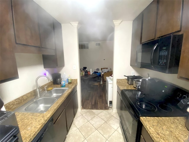 kitchen featuring dark brown cabinetry, sink, and black appliances