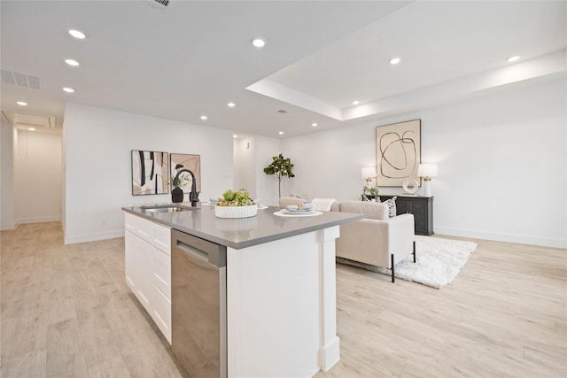 kitchen featuring sink, white cabinets, a kitchen island with sink, stainless steel dishwasher, and light hardwood / wood-style floors