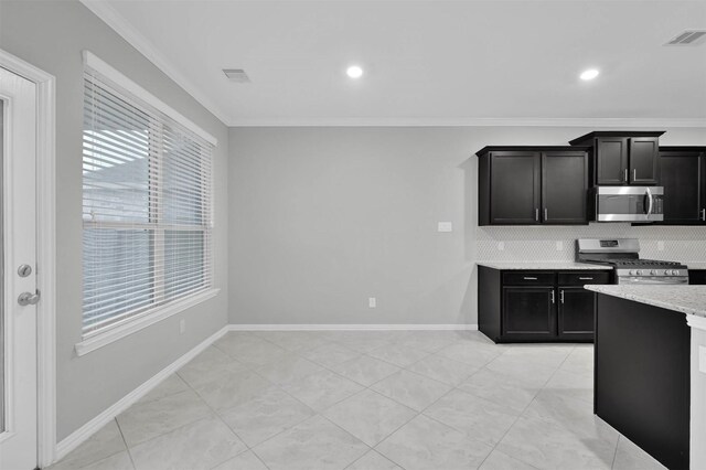 kitchen featuring tasteful backsplash, light tile patterned floors, ornamental molding, appliances with stainless steel finishes, and light stone countertops