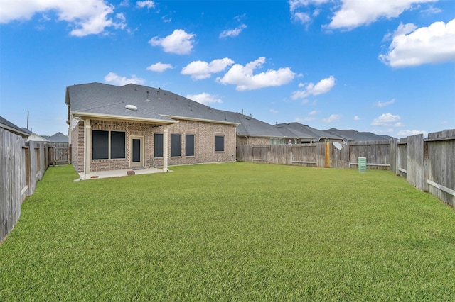 rear view of house featuring a lawn and a patio area