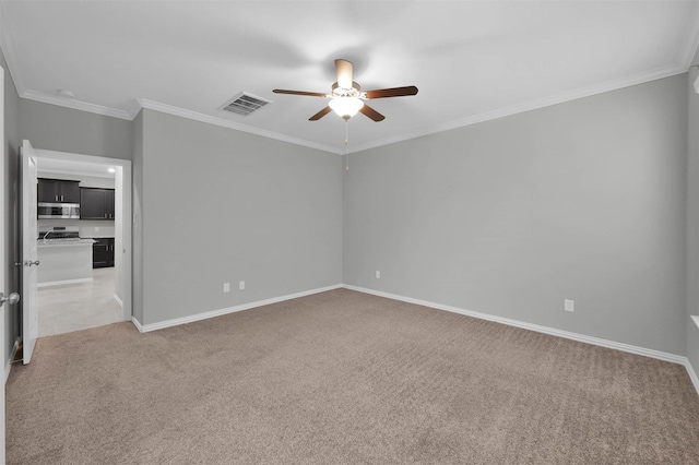 carpeted spare room with crown molding and ceiling fan