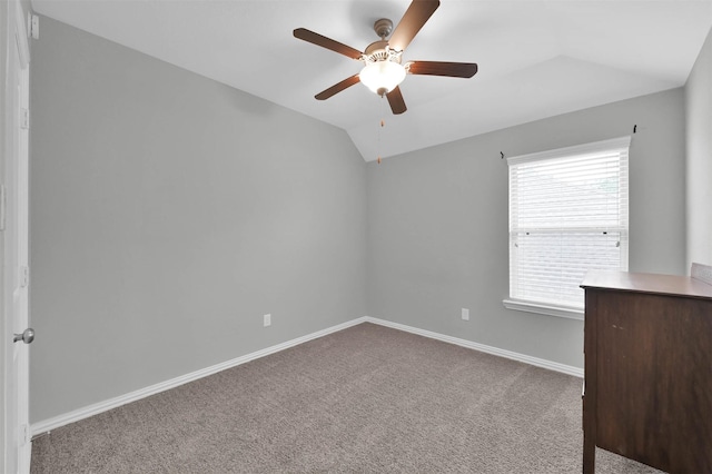 empty room featuring ceiling fan, light colored carpet, and vaulted ceiling