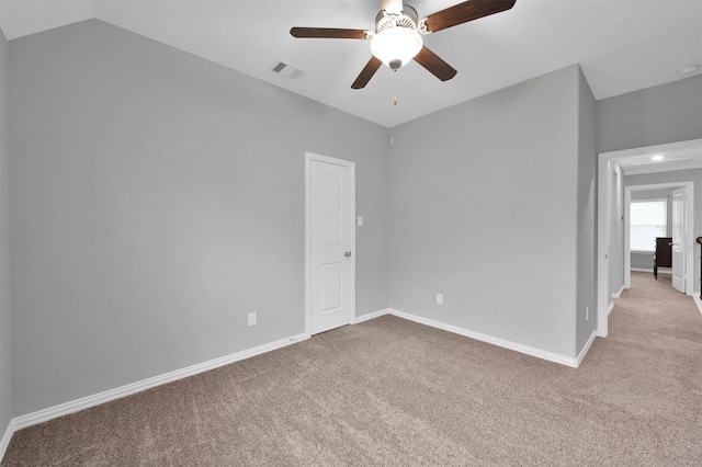 carpeted spare room featuring lofted ceiling and ceiling fan