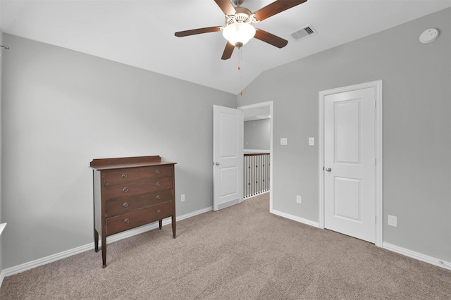 unfurnished bedroom with ceiling fan, light colored carpet, and vaulted ceiling