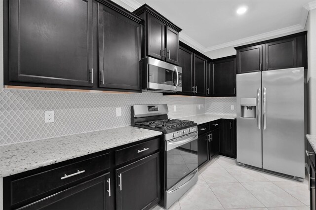 kitchen featuring light tile patterned floors, crown molding, stainless steel appliances, light stone counters, and decorative backsplash