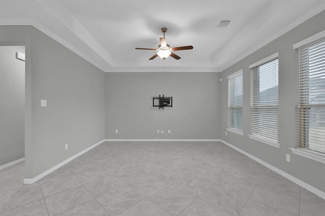 empty room with crown molding, ceiling fan, and a tray ceiling