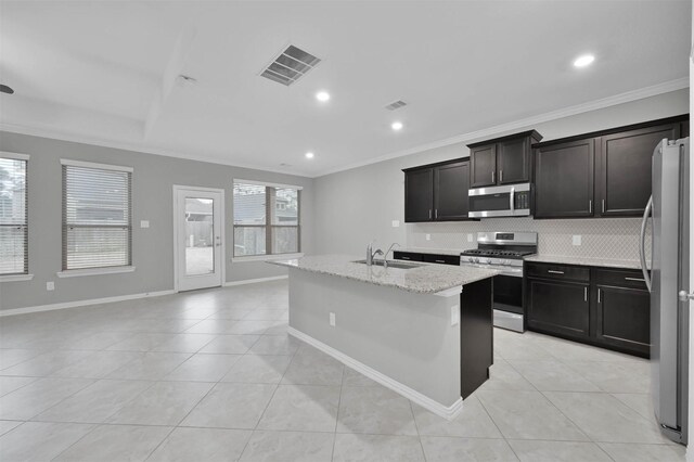 kitchen featuring crown molding, appliances with stainless steel finishes, sink, and a center island with sink