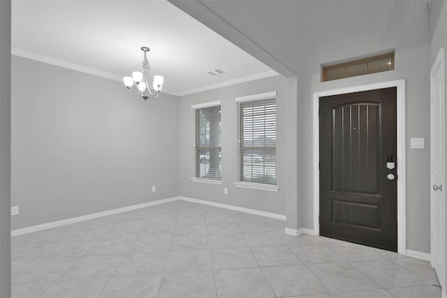 tiled foyer featuring crown molding and an inviting chandelier