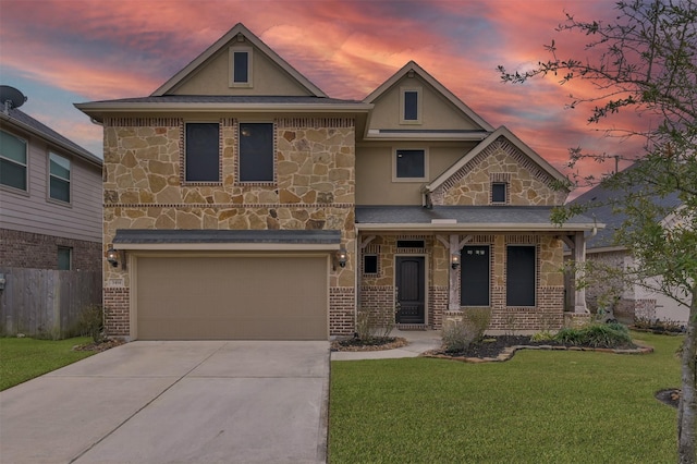 traditional-style home with a front yard, fence, driveway, stucco siding, and stone siding