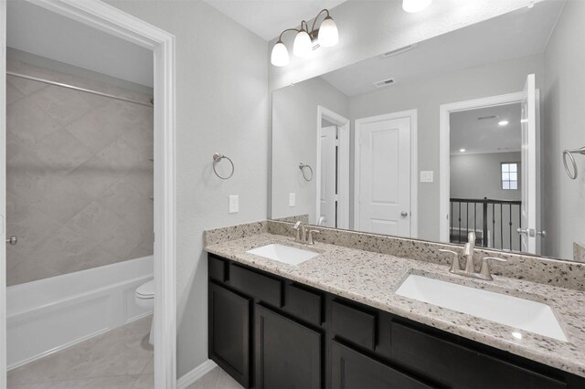 full bathroom with vanity, toilet, tiled shower / bath combo, and tile patterned flooring