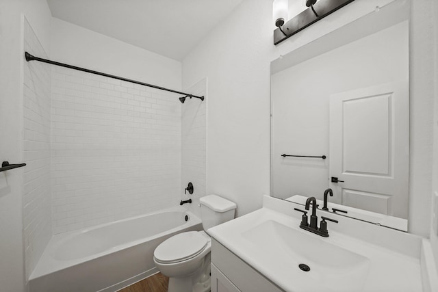 full bathroom featuring vanity, tiled shower / bath, hardwood / wood-style flooring, and toilet