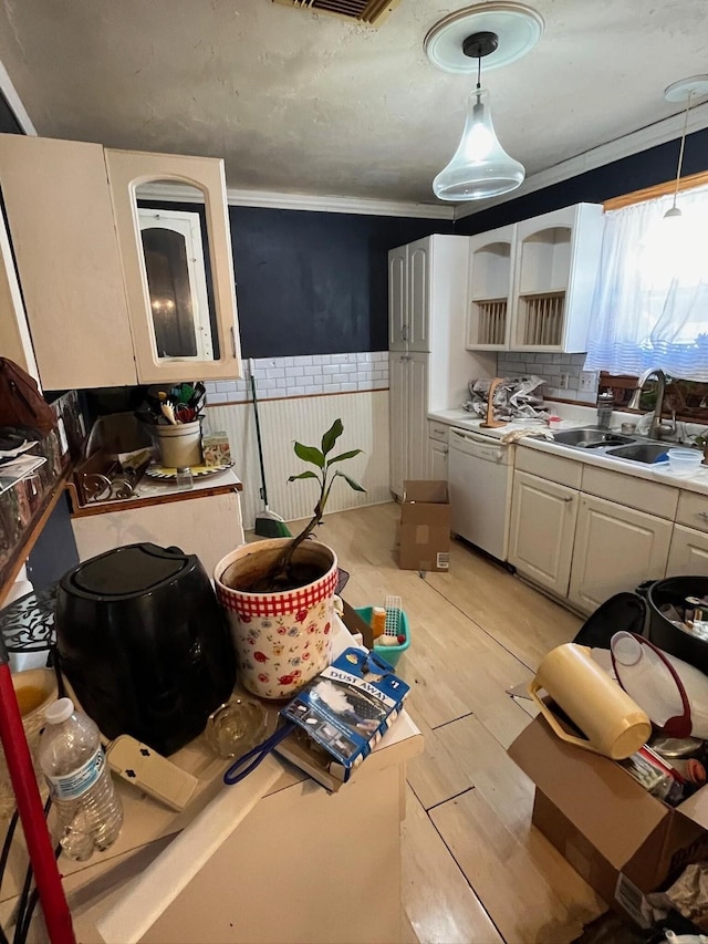 kitchen with pendant lighting, sink, dishwasher, white cabinetry, and light wood-type flooring