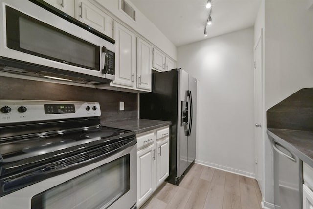 kitchen featuring appliances with stainless steel finishes, white cabinets, decorative backsplash, light hardwood / wood-style floors, and track lighting