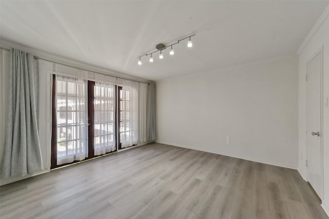 unfurnished room featuring crown molding, light hardwood / wood-style flooring, and rail lighting