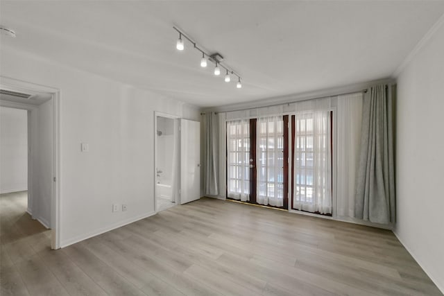 unfurnished room featuring track lighting and light hardwood / wood-style floors