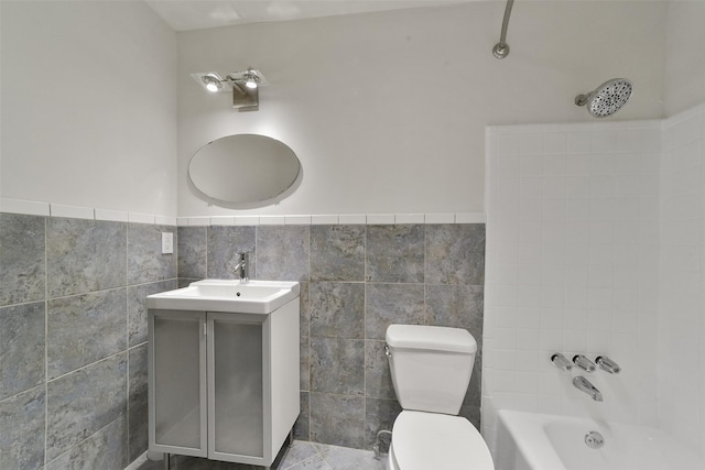 full bathroom with vanity, tile walls, shower / bathtub combination, and toilet