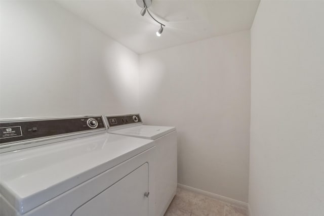 laundry room featuring rail lighting, washer and dryer, and light tile patterned floors