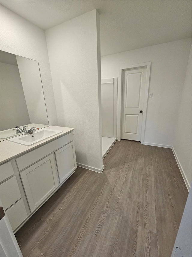 bathroom with vanity, hardwood / wood-style floors, and a shower