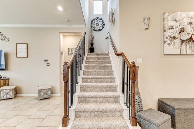 stairway with crown molding and tile patterned floors