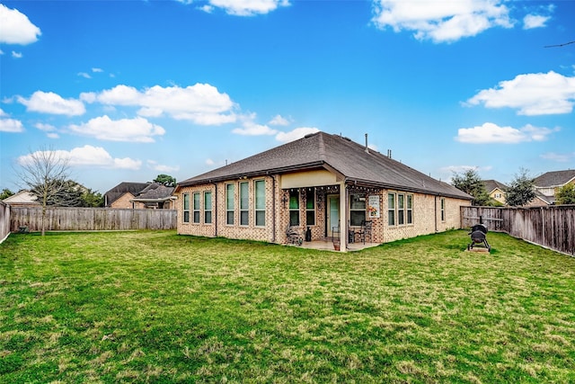 back of house with a patio and a lawn