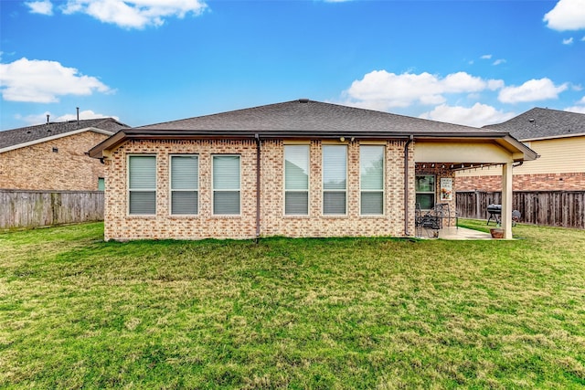 rear view of property featuring a patio area and a lawn