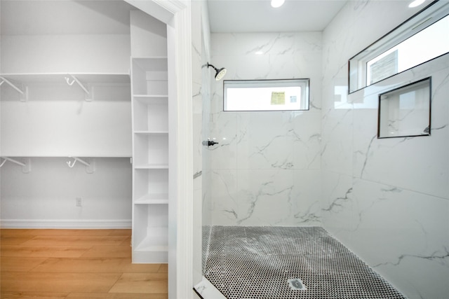 bathroom featuring hardwood / wood-style flooring and tiled shower