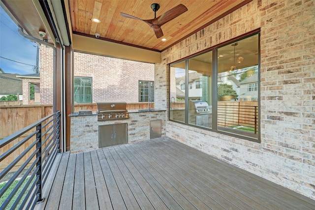 deck with an outdoor kitchen, area for grilling, and ceiling fan