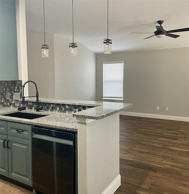 kitchen with light stone counters, sink, pendant lighting, and dark hardwood / wood-style flooring