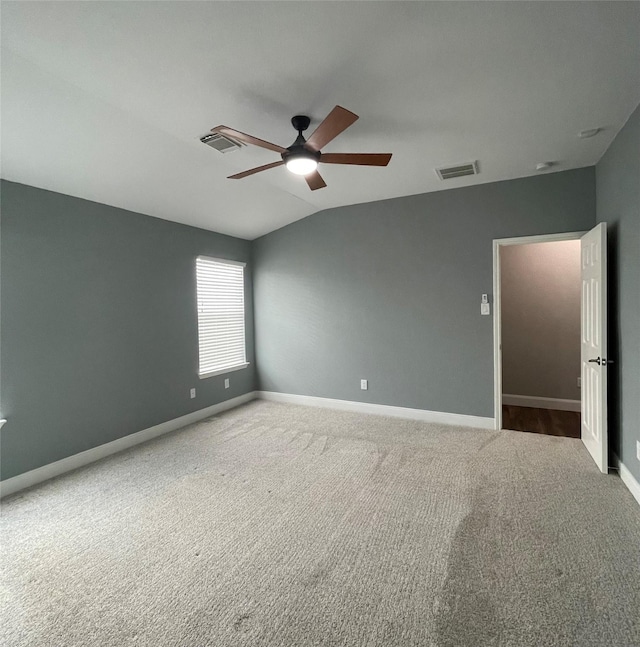 empty room featuring vaulted ceiling, carpet, and ceiling fan