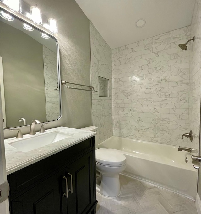 full bathroom with parquet floors, tiled shower / bath, vanity, and toilet