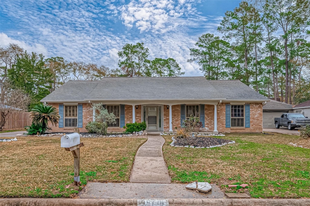 ranch-style house with a front yard and covered porch