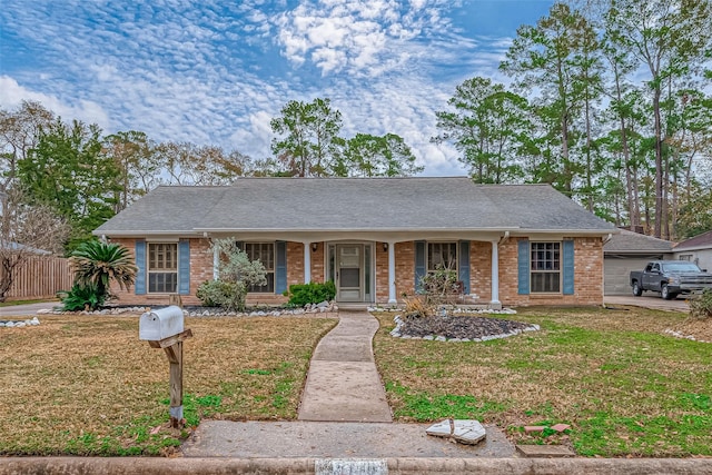 ranch-style house with a front yard and covered porch