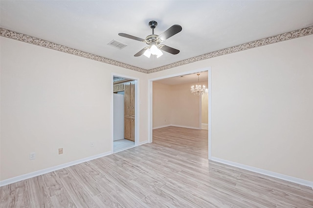 unfurnished room featuring ceiling fan with notable chandelier and light hardwood / wood-style flooring