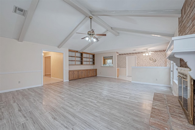 unfurnished living room with ceiling fan, a brick fireplace, vaulted ceiling with beams, and light wood-type flooring