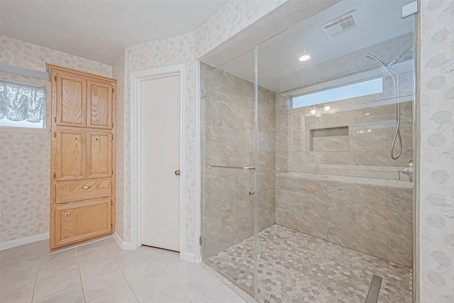 bathroom with a shower with shower door and tile patterned flooring