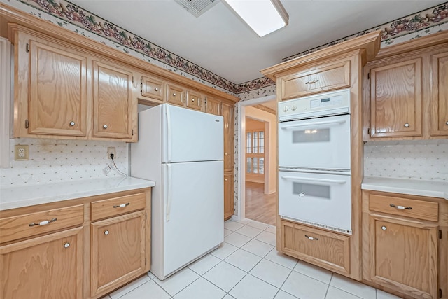 kitchen with white appliances, decorative backsplash, and light tile patterned floors