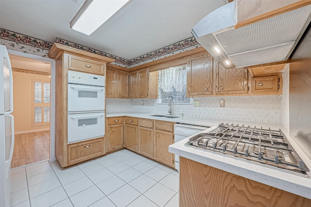 kitchen with premium range hood, tasteful backsplash, sink, light tile patterned floors, and white appliances