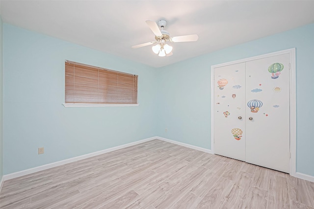 unfurnished bedroom featuring light hardwood / wood-style floors, a closet, and ceiling fan