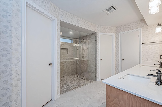 bathroom featuring a shower with door, vanity, and tile patterned flooring