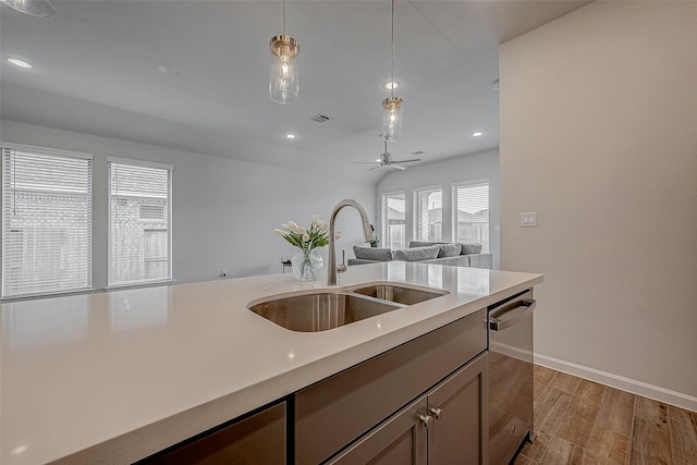 kitchen featuring sink, ceiling fan, dishwasher, decorative light fixtures, and light wood-type flooring