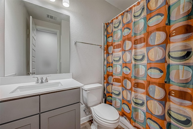 full bathroom featuring visible vents, a textured wall, toilet, a shower with curtain, and vanity